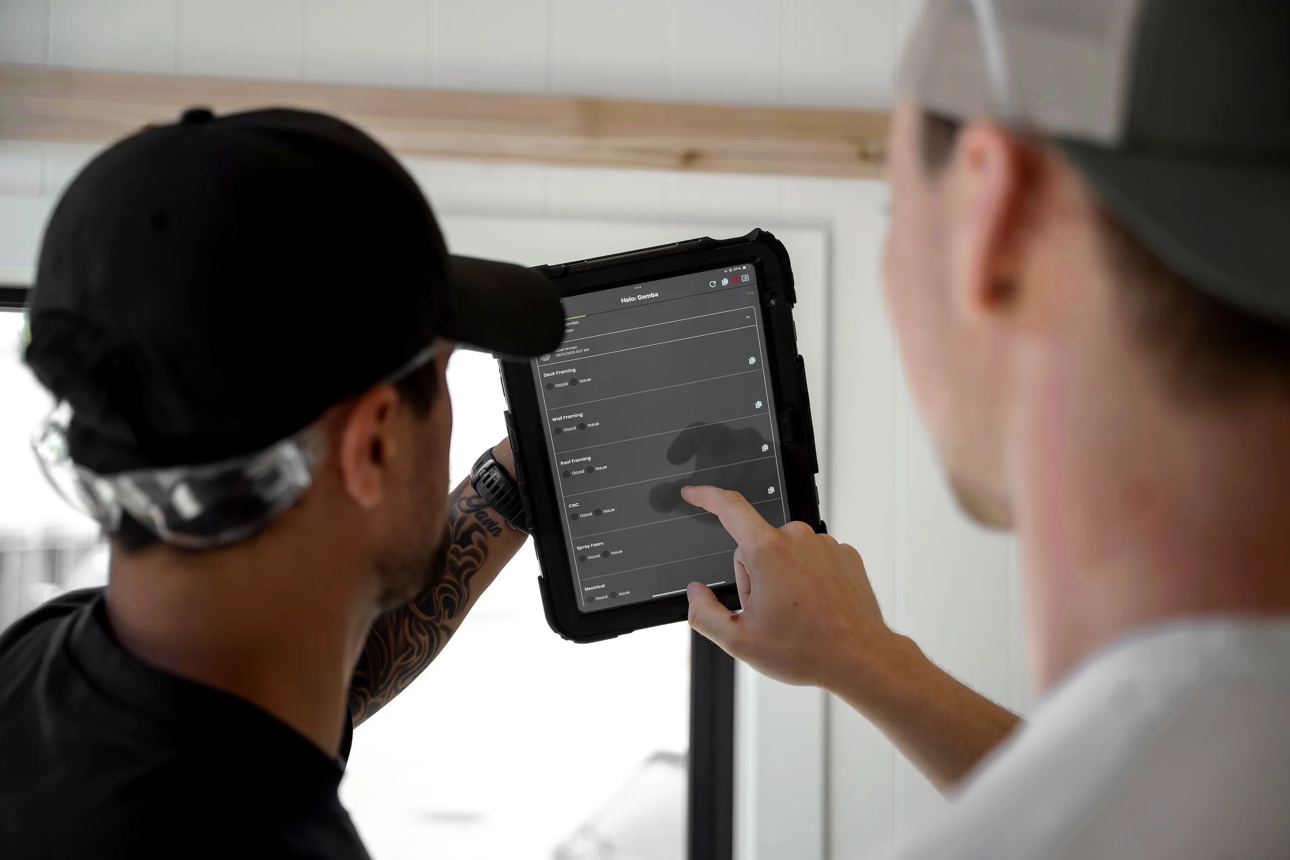 Two production workers reviewing an inspection checklist on a tablet