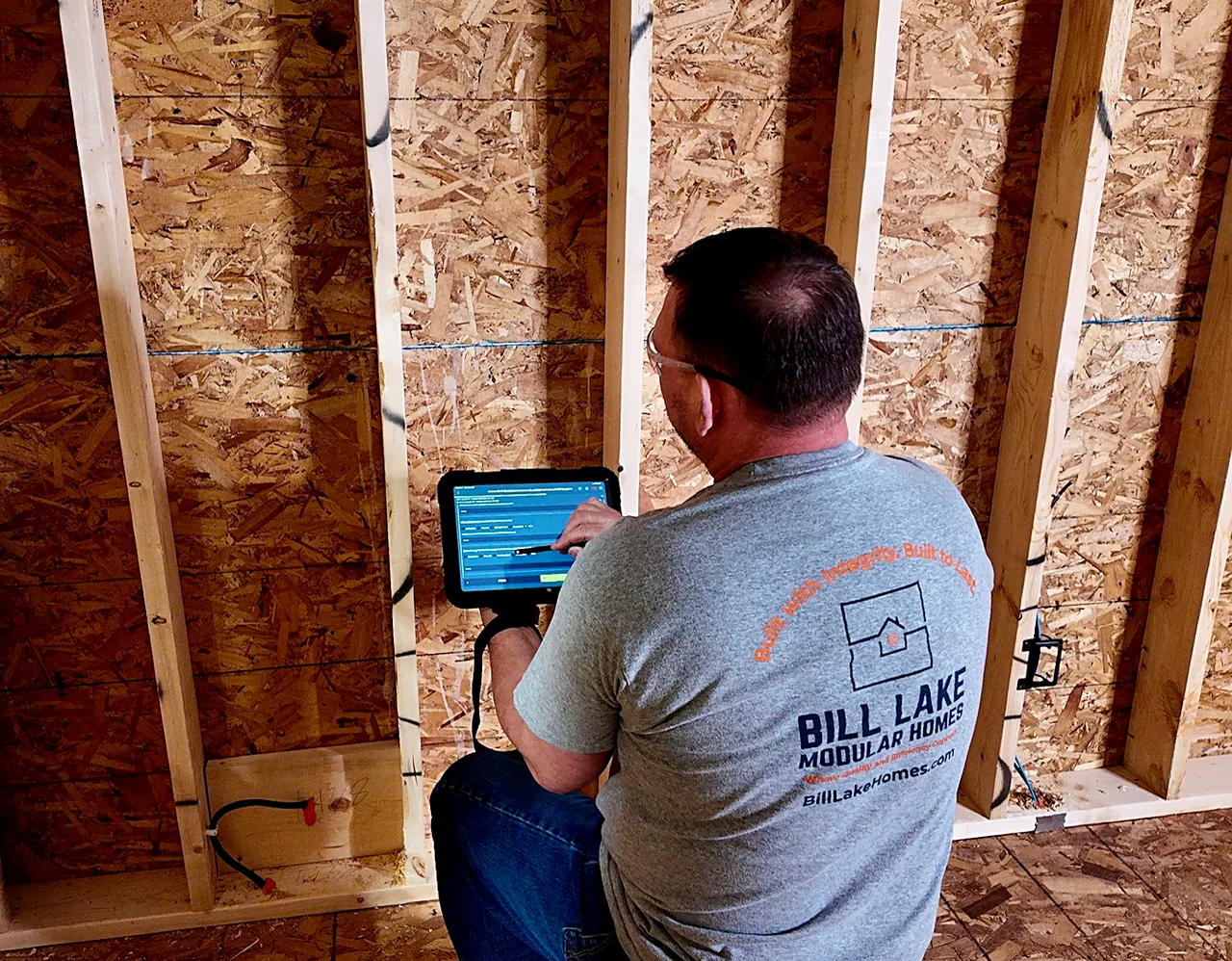 An engineer checking the build against the model on a tablet