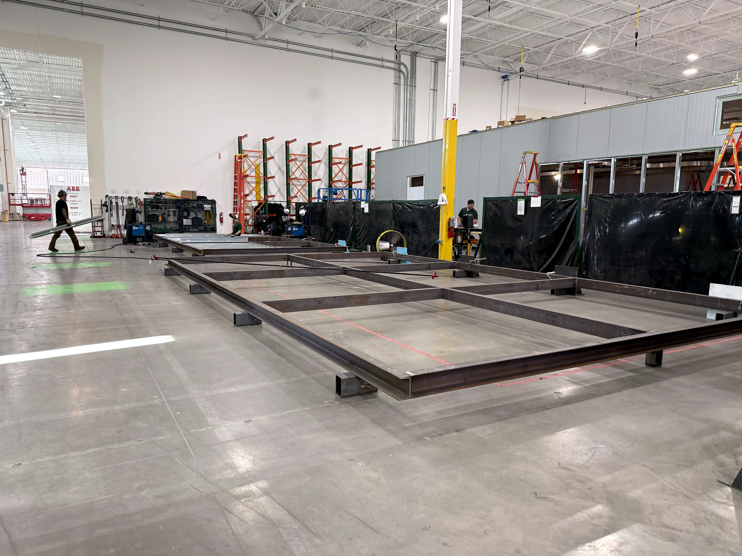 Steel bases laid out across the EIG electrical prefabrication floor