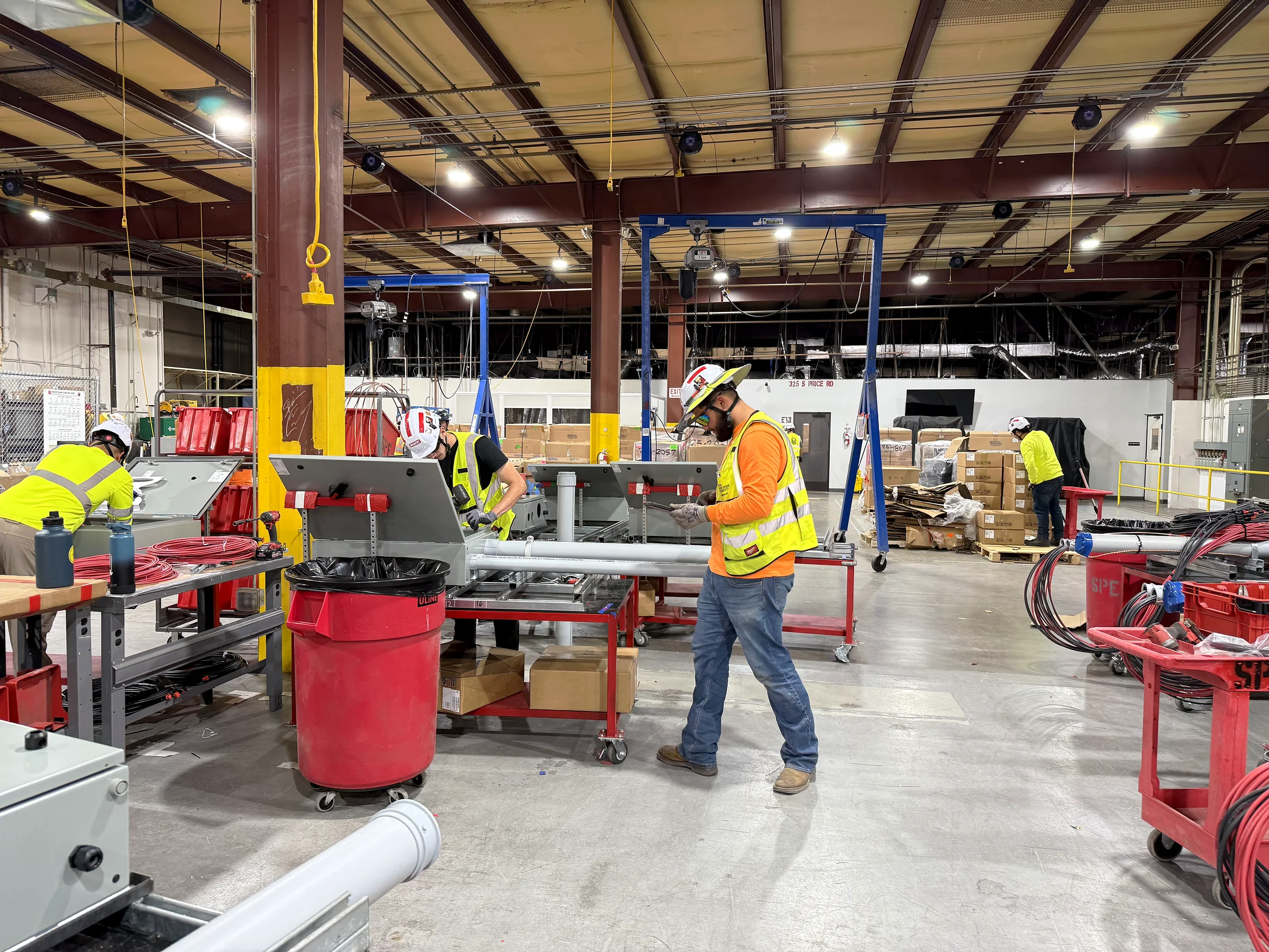 An electrical prefabrication shop, assemblies staged at the benches under the gantries