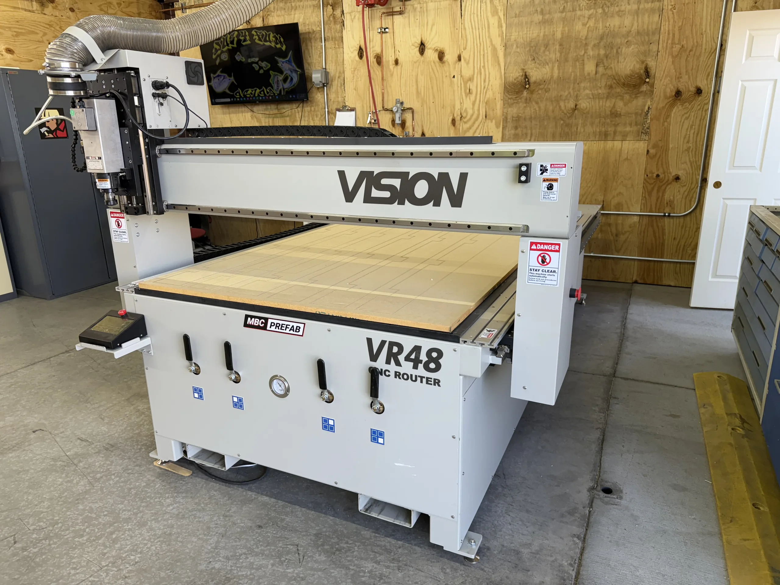 A CNC router loaded with sheet stock in a prefabrication shop