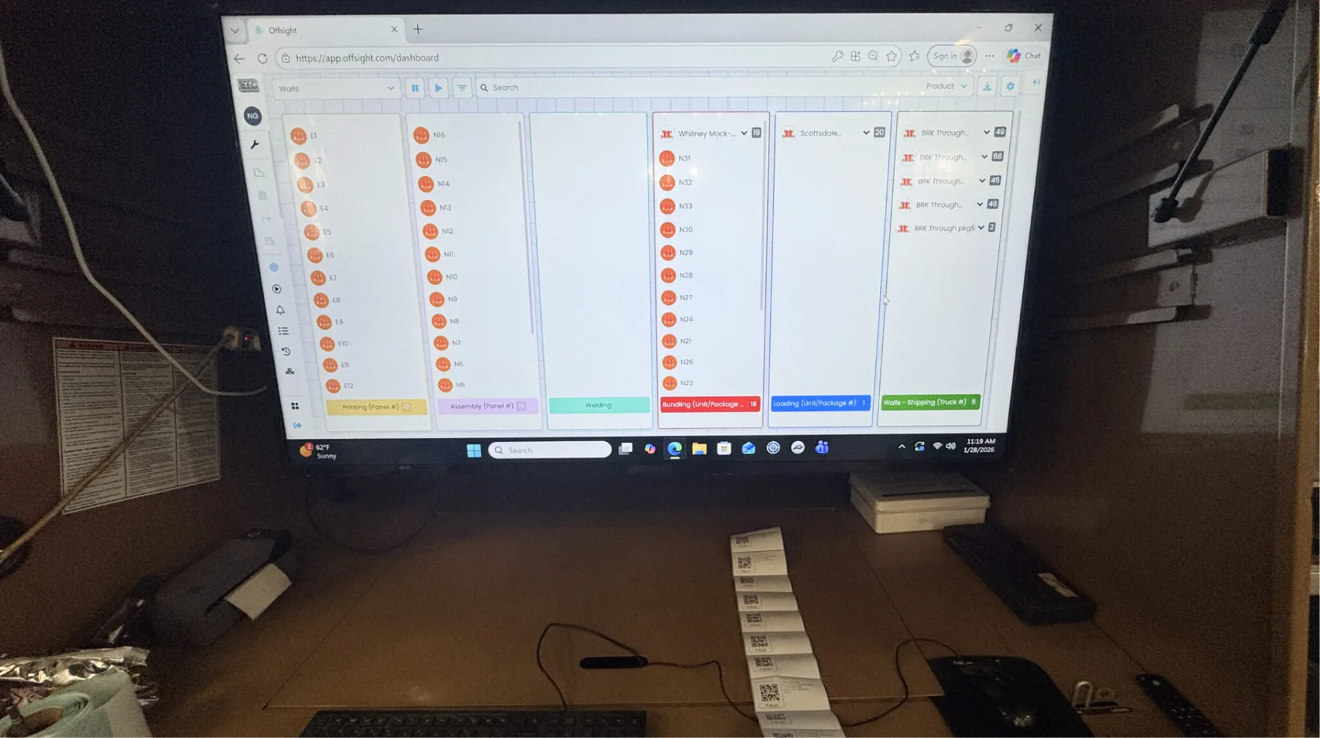 A MAC Prefab operator reviewing the Offsight production board and batch labels in the factory