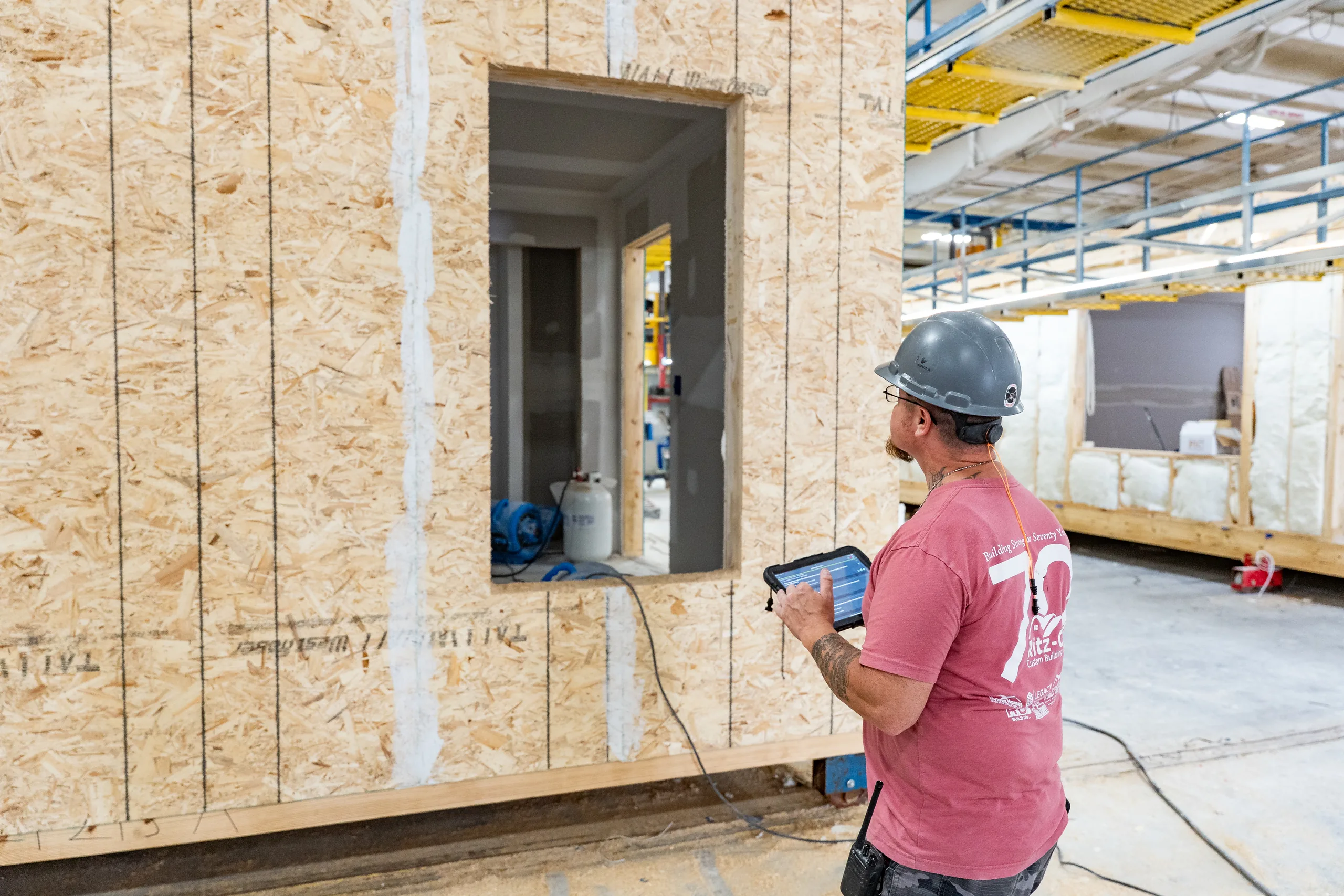 An inspector checking sheathing on a panel before it leaves the station