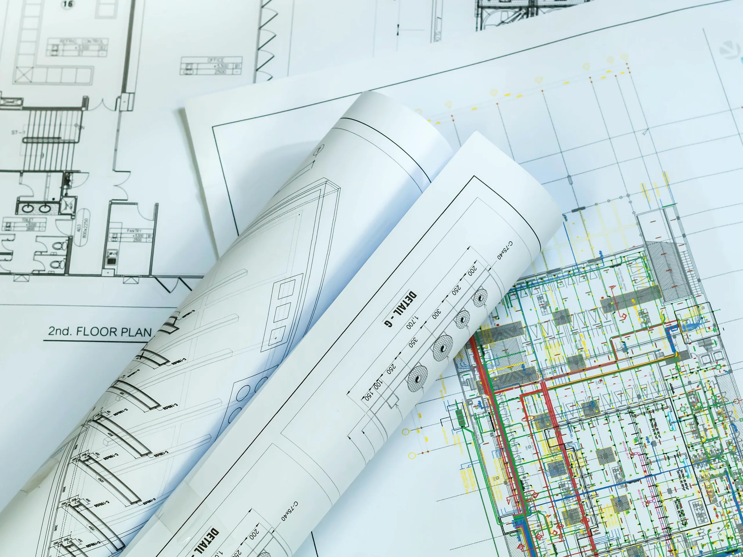 Technical drawings and rolled plans on a workbench