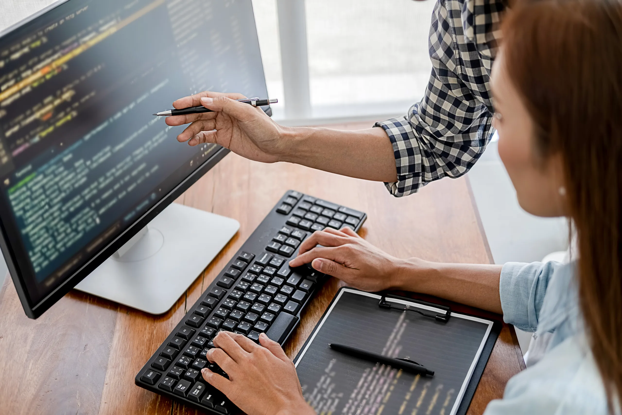 A developer working across multiple screens of code